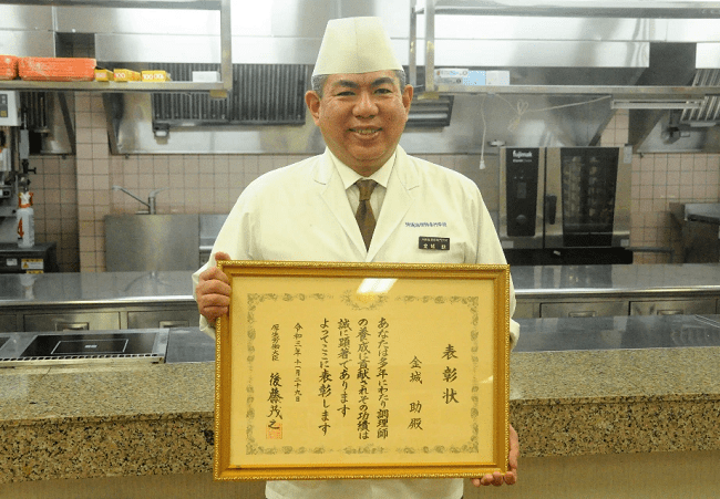 Kinjo Hiro nhận bằng khen của Bộ Y tế, Lao động và Phúc lợi. Ảnh: Ảnh do Trường dạy nấu ăn Okinawa