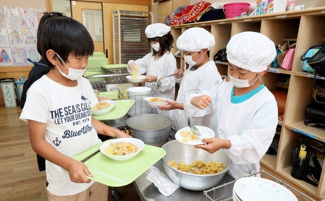 Các học sinh tự phục vụ bữa trưa ở trường